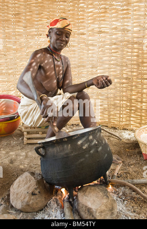 Bedik africani le donne con velo di cottura di arachidi schiacciato sul fuoco, Iwol village, paese Bassari, Senegal Africa. Foto Stock