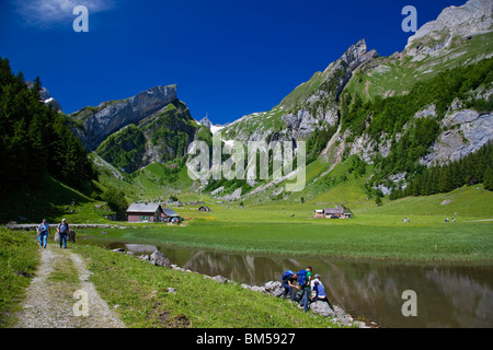 Gli escursionisti vicino Lago Seealpsee sull Alpstein montagne, Mt Saentis nel retro, Canton Appenzello Interno, Svizzera, Europa Foto Stock