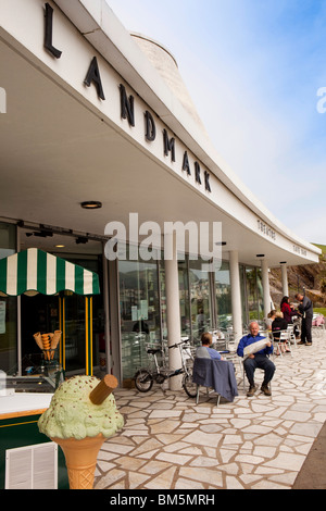 Regno Unito, Inghilterra, Devon, Ilfracombe, Promenade, visitatori seduti fuori Landmark Theater café nella luce del sole Foto Stock