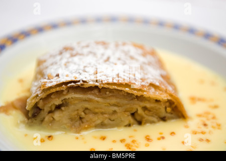 Strudel di mele (Apfelstrudel) è servita con crema pasticcera (Vanillesoße) in Baviera, Germania. Foto Stock