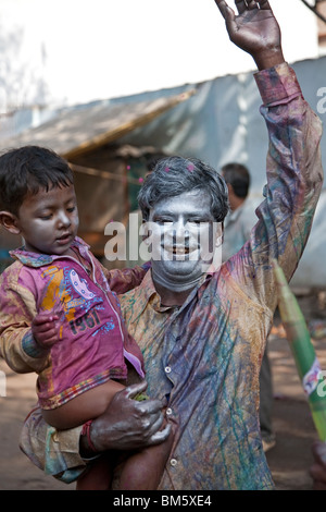 Padre e figlio per celebrare la colorata Holi festival. Varanasi. India Foto Stock