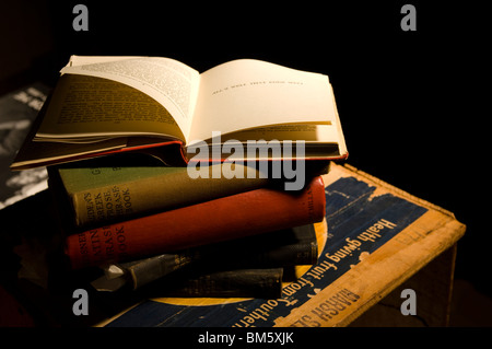 Una pila di vecchi libri su una cassetta con il lato superiore TOP libro aperto per mostrare le pagine di tornitura Foto Stock