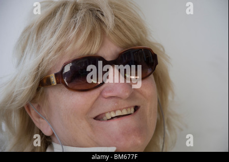 Donna sorridente indossando occhiali da sole Foto Stock