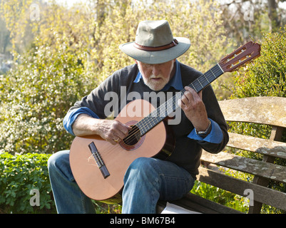 Uomo anziano suonare la chitarra classica all'aperto Foto Stock