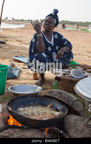 Una donna vende pesce fritto per i viaggiatori al traghetto per Djenne, Mali. Foto Stock