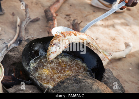 Una donna vende pesce fritto per i viaggiatori al traghetto per Djenne, Mali. Foto Stock