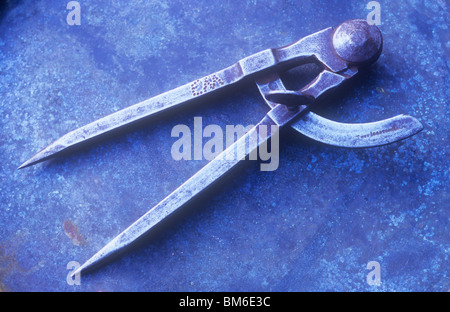 Coppia di vecchi divisori metallici giacente sul foglio di metallo Foto Stock