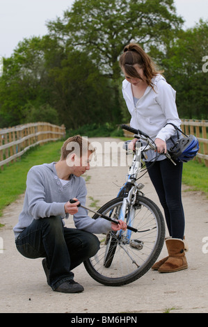 Giovani adolescenti ragazzo e una ragazza di gonfiare il pneumatico della sua bicicletta Foto Stock