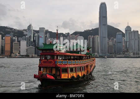 Cinese barca watertour, 'Phoenix', avvicinando il Tsim Sha Tsui Promenade, contro uno sfondo di grattacieli centrale, Hong Kong Foto Stock