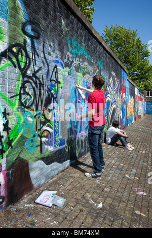 Teenage Street artist dipinto sulla DPM Hall of fame; Legal graffiti tag wall intorno alla strada principale, Dundee City, Scozia, Regno Unito Foto Stock