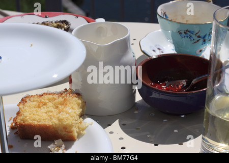 Un pomeriggio tea party è in corso con torta stand, stoviglie e metà limone finito pioggerella spugna Foto Stock