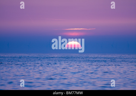 Silhouette di un vento turb contro il sorgere del sole. Thanet Offshore wind farm in Kent, Inghilterra. Mondi del parco eolico offshore più grande. Foto Stock