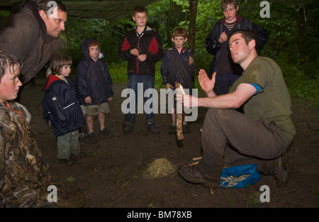 I bambini vengono insegnati bushcraft competenze da parte di istruttore in corso nel bosco a Gower Swansea South Wales UK Foto Stock