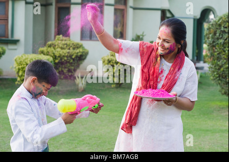 Donna che gioca holi con suo nipote Foto Stock