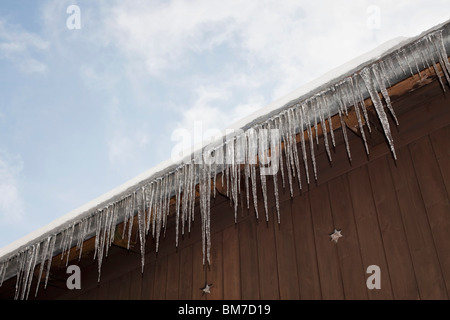 Dettaglio di ghiaccioli appesi da un tetto Foto Stock