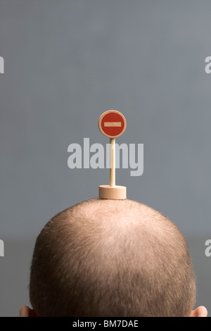 Un uomo con una miniatura nessuna voce cartello stradale sulla sua testa Foto Stock