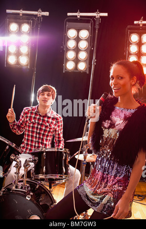 Una donna cantante accompagnato da un uomo su tamburi di eseguire sul palco Foto Stock