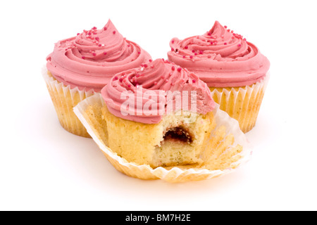 Tre coppa rosa torte su uno sfondo bianco con un morso prese Foto Stock