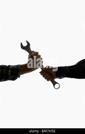 Un lavoratore edile di consegnare una chiave per un altro lavoratore, concentrarsi sulle mani Foto Stock