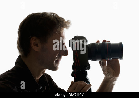 Un fotografo lavorando con una telecamera su un treppiede Foto Stock