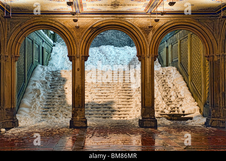 Coperta di neve passi all'estremità sud del Central Park di Bethesda Terrazza come visto attraverso gli archi di notte Foto Stock