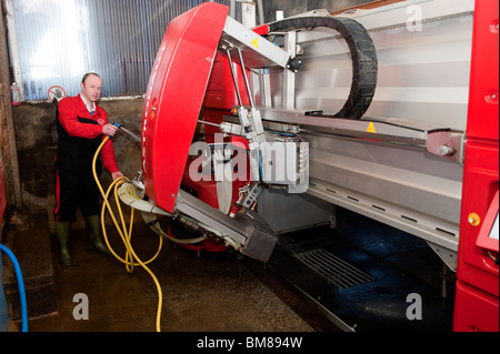 Agricoltore il lavaggio di mungitura robotizzata parlor Foto Stock