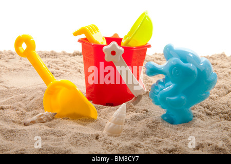 Giocattoli di plastica per la spiaggia di sabbia su sfondo bianco Foto Stock