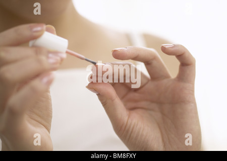 Giovane donna la lucidatura di chiodi, close up Foto Stock