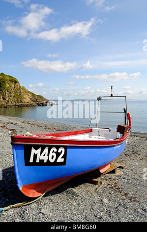 Una piccola barca da pesca ormeggiate sulla spiaggia di ciottoli a porthallow in cornwall, Regno Unito Foto Stock