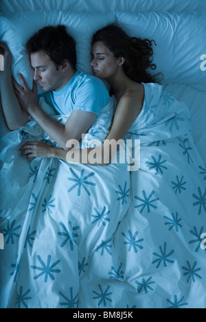 Giovane dormendo, donna che comprenda l'uomo Foto Stock