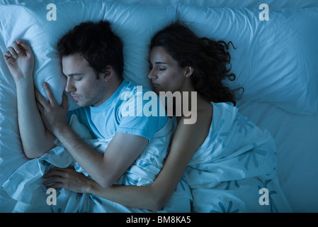 Giovane dormendo, donna che comprenda l'uomo Foto Stock