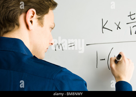 Uomo equazione di scrittura su whiteboard Foto Stock