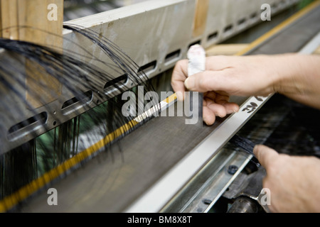 Rivestimento in tessuto vegetale, dipartimento di tessitura, mechanist preparazione tessitore pettine sul telaio Foto Stock