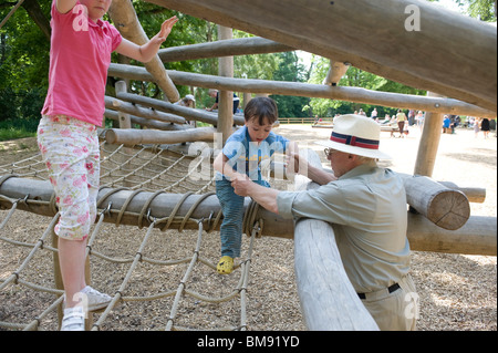 Nonno aiutando il suo nipote e nipote su un gioco di avventura massa al Castle Howard , North Yorkshire Foto Stock