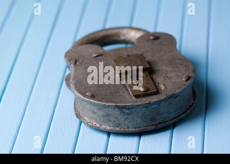 Il vecchio blocco arrugginito sul blu sullo sfondo di legno Foto Stock