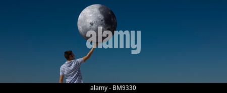 Concetto di ecologia, man tenendo la luna Foto Stock