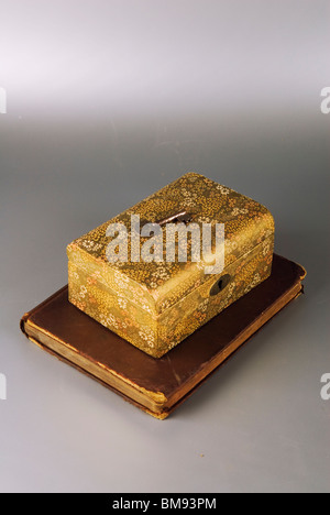 Vecchia scatola di gioielli con una chiave su un vecchio libro Foto Stock