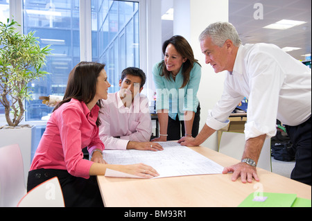 Riunione del team di discutere di disegni in pianta ad architetti di Office Foto Stock