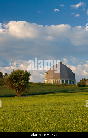 Whitman County, WA sole mattutino sul round barn sotto cieli di compensazione Foto Stock