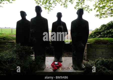 Il papavero corona al piede di sculture in Langemarck cimitero di guerra tedesco, nei pressi di Ypres Foto Stock