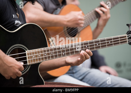 I chitarristi di strada. I musicisti suonano chitarre. Close-up di dita premendo le corde dello strumento. Foto Stock