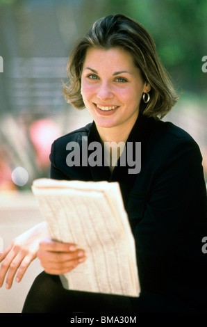 La donna legge giornale all'esterno. Foto Stock
