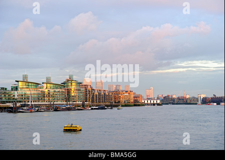 Il lusso tipico Thames riverside sviluppo, Wapping, East End di Londra, Inghilterra, Regno Unito, con Canary Wharf in background Foto Stock