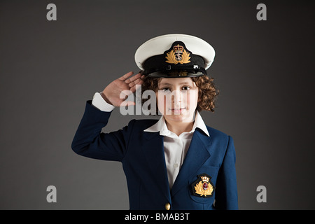 Ragazzo giovane vestito in costume marinaio, salutando Foto Stock