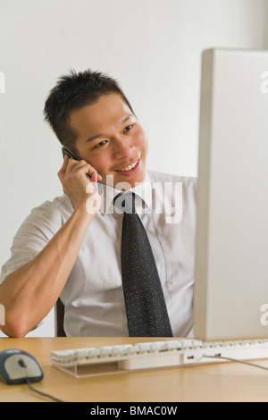 Imprenditore parlando al telefono cellulare in ufficio Foto Stock