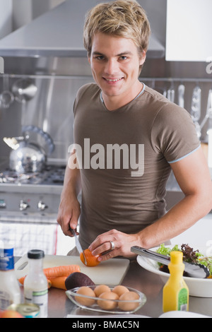 L'uomo tritare verdure in cucina Foto Stock