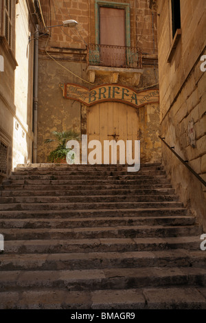 Scale antiche scale portano ad un portale di Birgu (Vittoriosa), Valletta, Malta. Il portale è ad archi e ha un segno "Briffa' sopra. Foto Stock