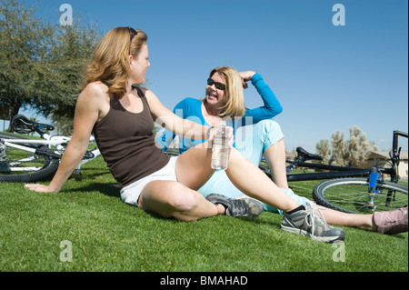 Due amici sedersi a parlare con le loro biciclette Foto Stock