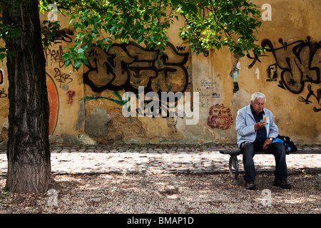 Il vecchio uomo è mangiare un panino all isola di Kampa a Praga Foto Stock