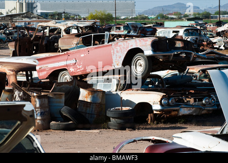 I vecchi veicoli di essere riciclata per parti di ricambio e rottami di metallo in un auto salvage yard Foto Stock